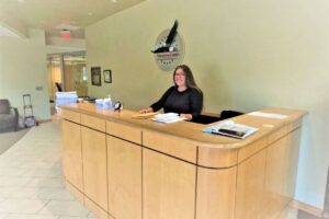 A smiling woman sitting at a reception desk