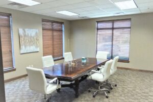 A rectangular table surrounded by white office chairs