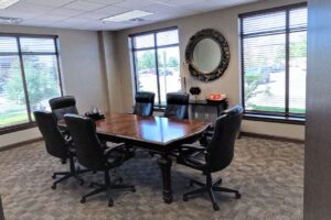 Black office chairs surround a rectangular table