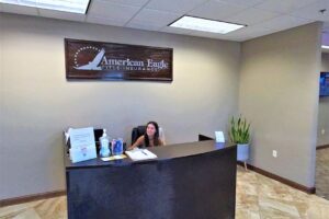 A smiling woman sits at a reception desk