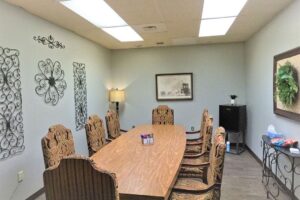 Chairs surround a rectangular table with curved sides