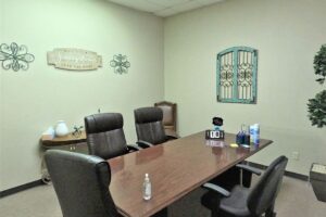 A rectangular table surrounded by black office chairs