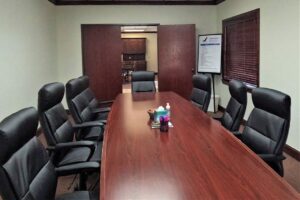 A brown table surrounded by black office chairs