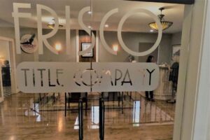 The interior of the Frisco Title Company, behind a door with text that reads "Frisco Title Company"