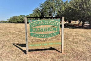 A sign which reads "Logan County Abstract Company; American Eagle Title group"