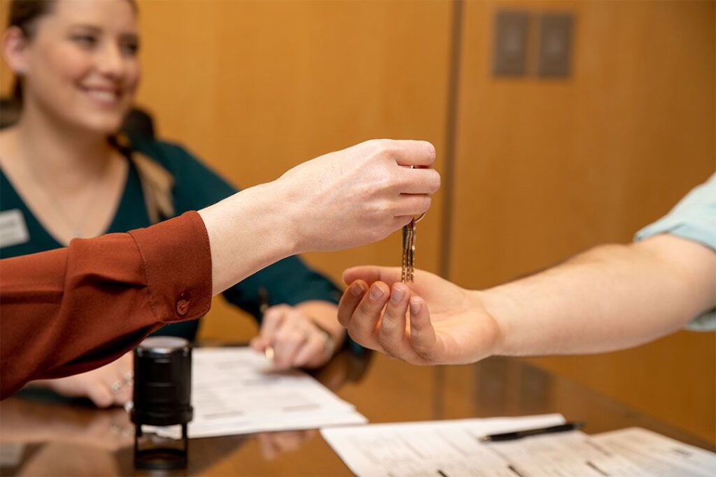 Someone holding a set of keys is placing them in the palm of someone else's hand