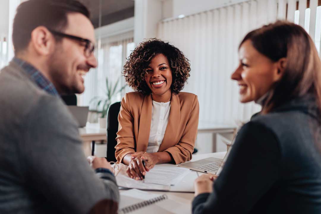 Man and women meeting an agent at her desk for commercial closing services